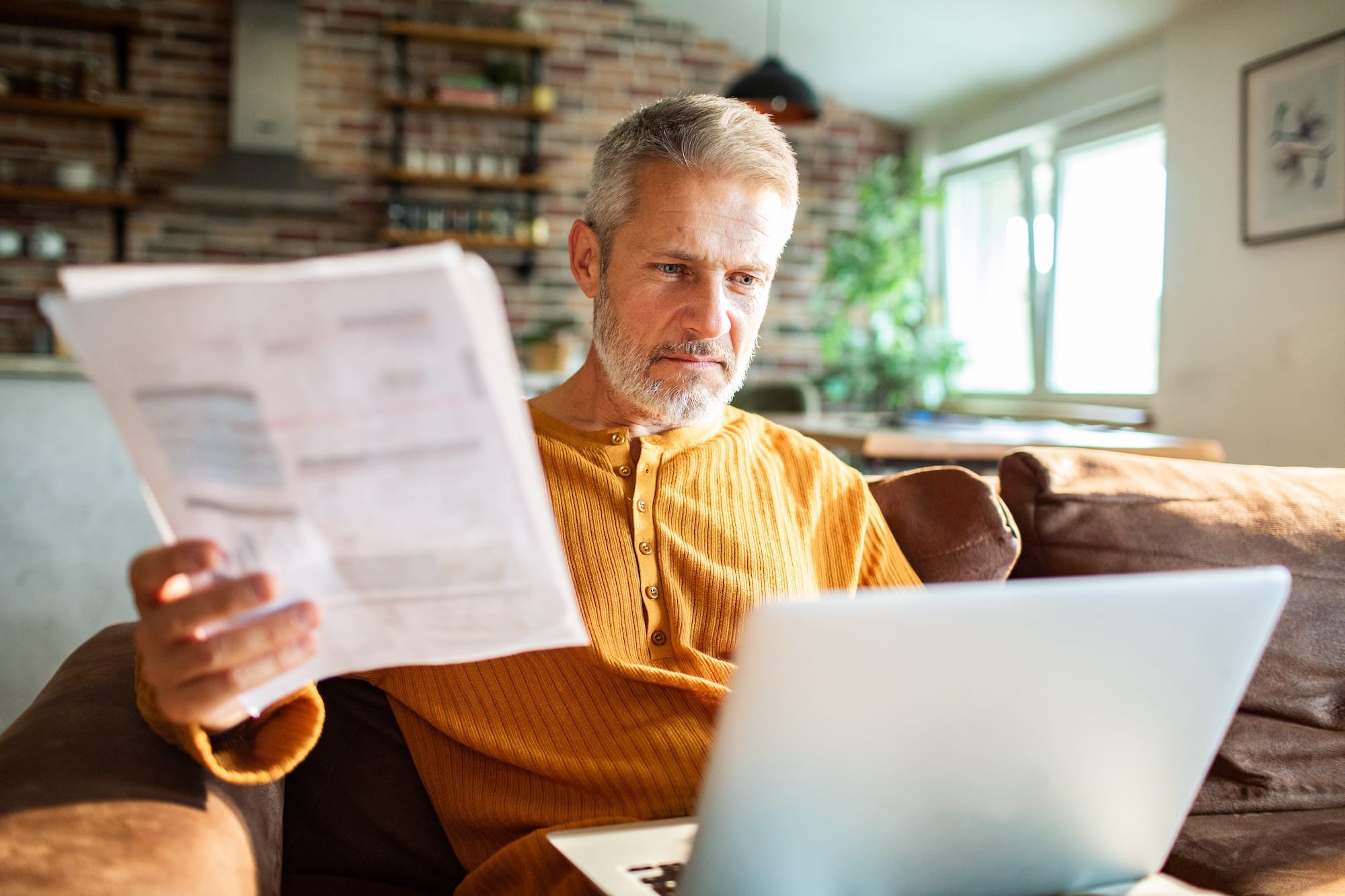 Mature man reviewing documents at home